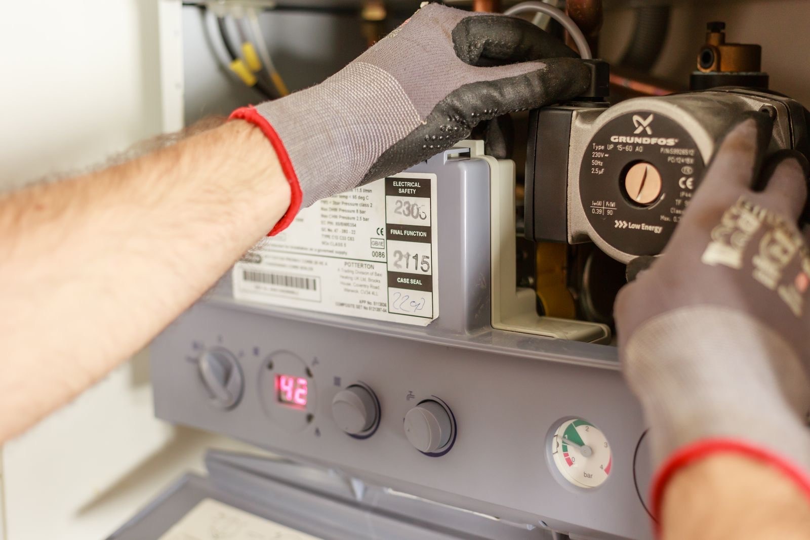 stock photograph of a heating engineer inspecting the inside of a boiler. Licensed stock picture, not a photograph of Always Plumbing Services Ltd, its staff, its premises or a job it carried out.